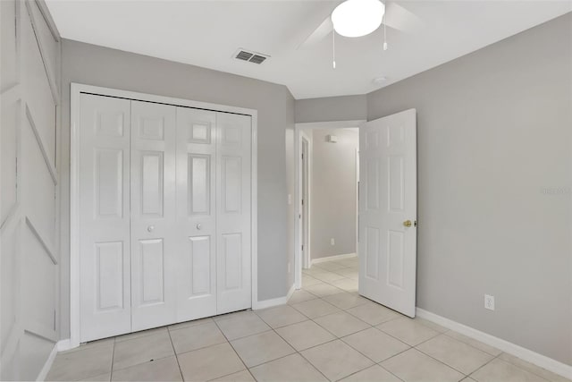 unfurnished bedroom with a closet, ceiling fan, and light tile patterned floors