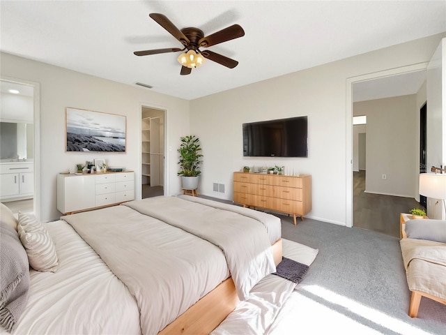 bedroom with connected bathroom, a walk in closet, a closet, and ceiling fan