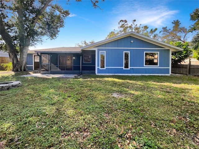 rear view of house with a yard and a sunroom