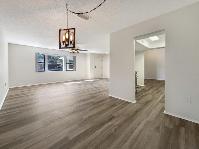 unfurnished living room with dark wood-type flooring, a textured ceiling, and ceiling fan with notable chandelier