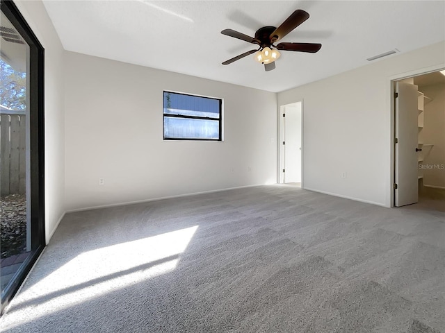 unfurnished room with a wealth of natural light, light carpet, and ceiling fan