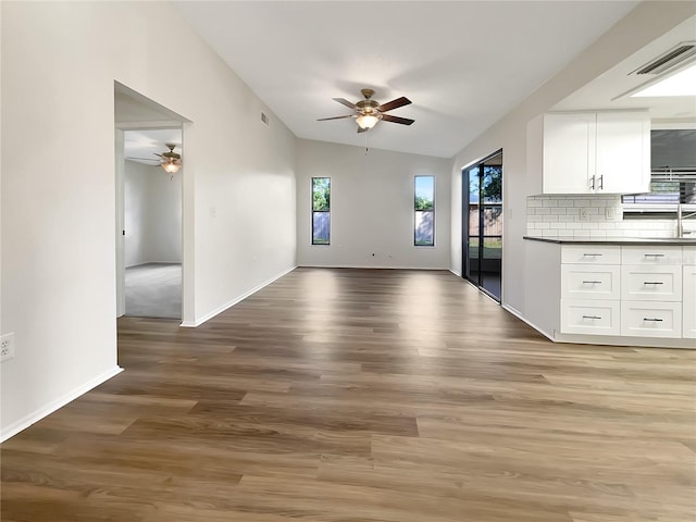 interior space featuring light hardwood / wood-style flooring, ceiling fan, sink, and vaulted ceiling