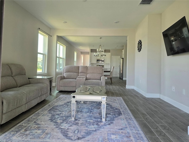 living room with dark hardwood / wood-style flooring and a chandelier