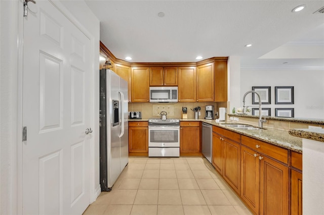 kitchen with crown molding, sink, stainless steel appliances, light stone counters, and light tile patterned floors