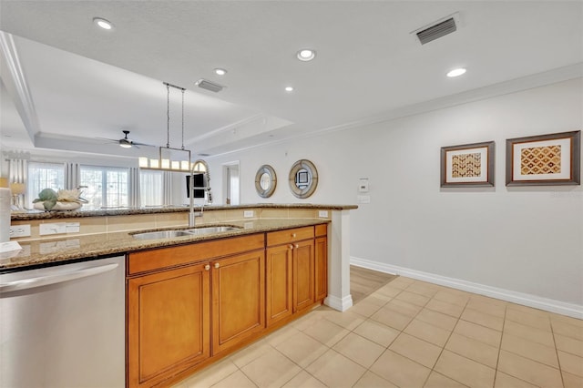 kitchen featuring hanging light fixtures, light stone countertops, a tray ceiling, dishwasher, and sink