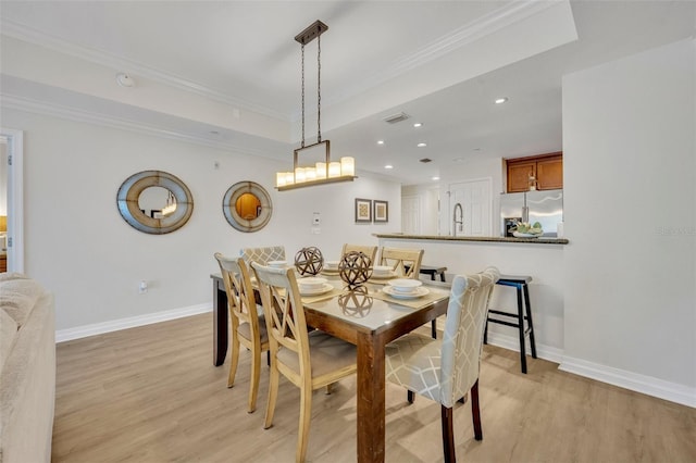 dining space featuring crown molding and light wood-type flooring