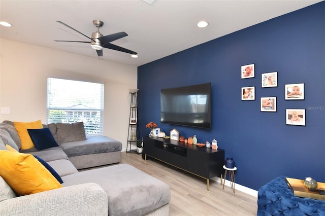 living room with light hardwood / wood-style flooring and ceiling fan