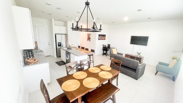 tiled dining area featuring a chandelier and sink