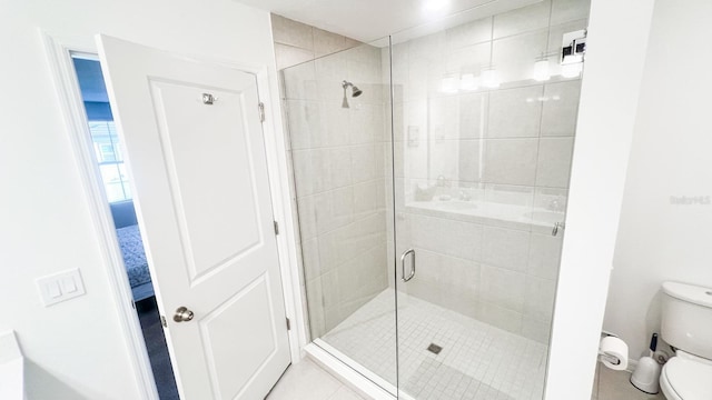 bathroom with a shower with door, tile patterned floors, and toilet