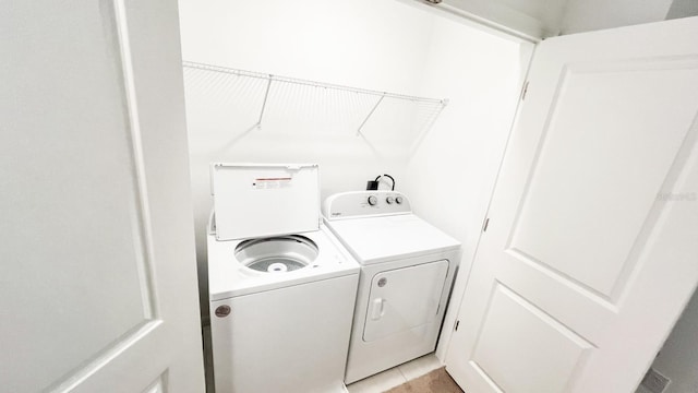 laundry room featuring washer and clothes dryer and light tile patterned floors