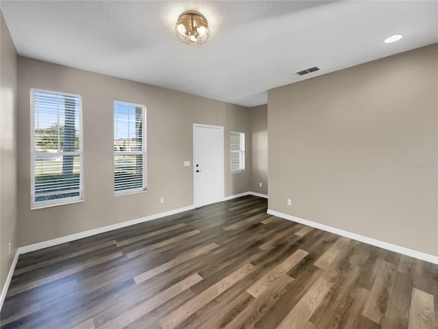 unfurnished room featuring dark wood-type flooring and a textured ceiling