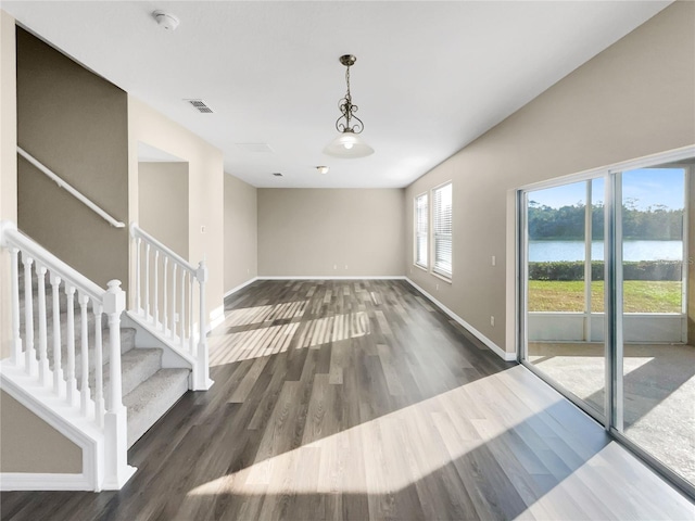 spare room featuring a water view and dark hardwood / wood-style flooring