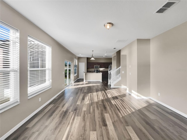 unfurnished living room with dark wood-type flooring