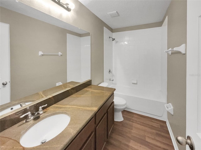 full bathroom featuring vanity, toilet, hardwood / wood-style flooring, and tiled shower / bath combo