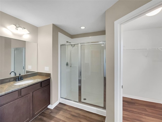 bathroom featuring a shower with door, hardwood / wood-style flooring, and vanity