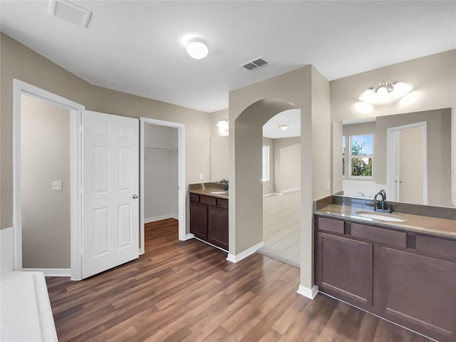 kitchen featuring dark brown cabinets, sink, and dark wood-type flooring