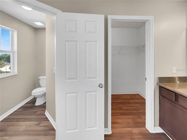 bathroom with vanity, toilet, and wood-type flooring