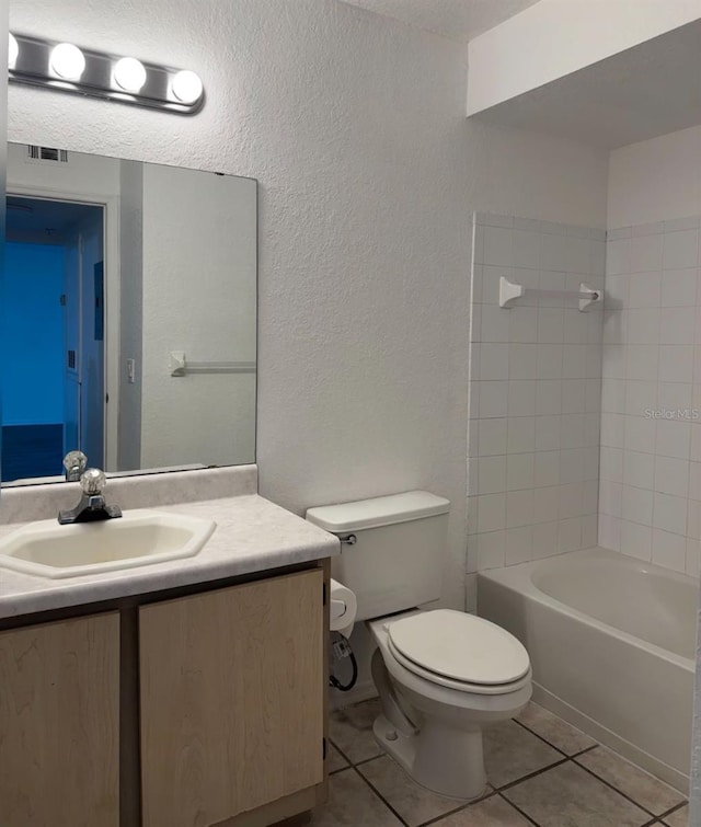 full bathroom featuring toilet, tiled shower / bath combo, vanity, and tile patterned floors