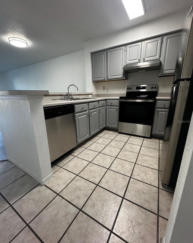 kitchen featuring gray cabinets, stainless steel appliances, sink, and light tile patterned flooring