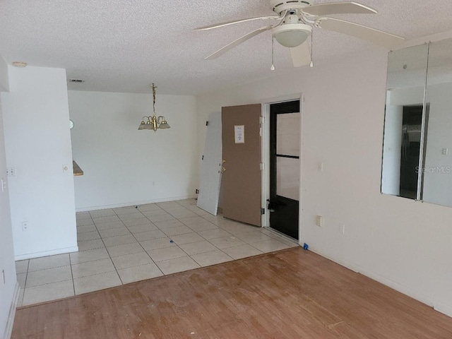 spare room with light hardwood / wood-style flooring, a textured ceiling, and ceiling fan