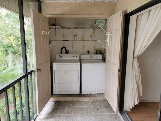 laundry room with washing machine and dryer and light wood-type flooring