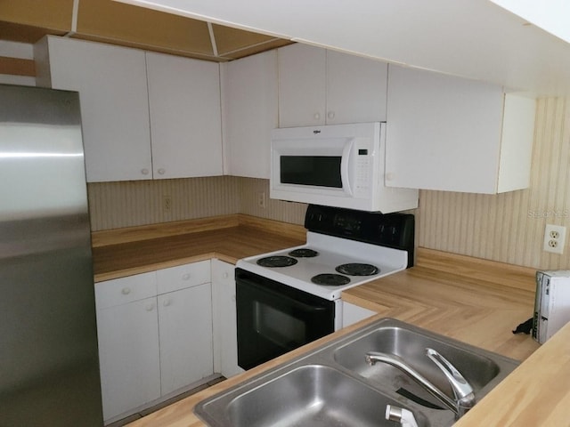 kitchen with white appliances, white cabinetry, sink, and wooden counters