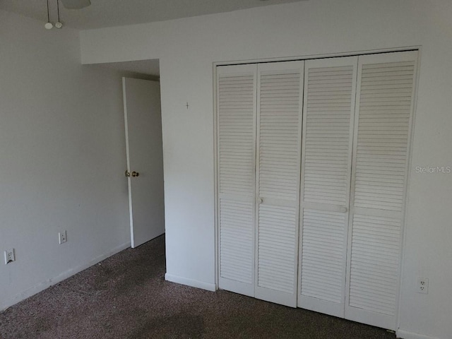 unfurnished bedroom featuring a closet and dark colored carpet