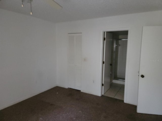 unfurnished room featuring dark colored carpet and ceiling fan