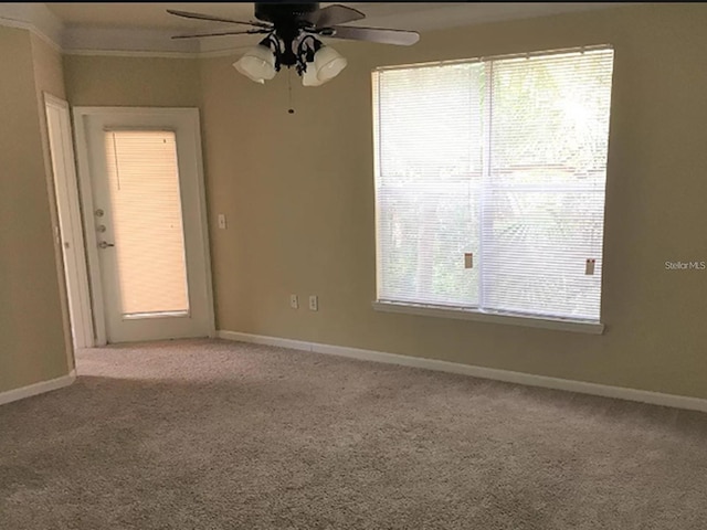 empty room with ornamental molding, light carpet, a healthy amount of sunlight, and ceiling fan