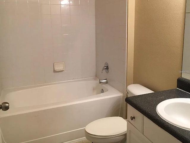 full bathroom with vanity, tiled shower / bath, and toilet