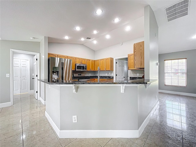 790 Silhouette Ct, Longwood, FL 32750 - kitchen with appliances with stainless steel finishes, baseboards, dark stone counters, lofted ceiling, and a breakfast bar
