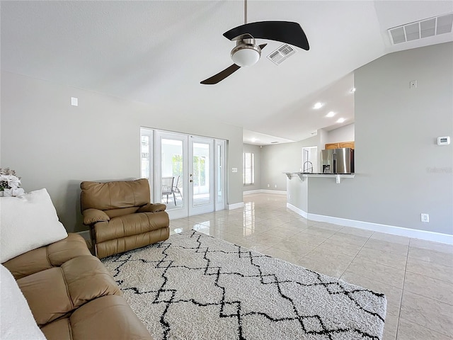 living area featuring french doors, visible vents, vaulted ceiling, and light tile patterned floors