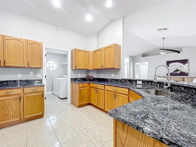 790 Silhouette Ct, Longwood, FL 32750 - kitchen featuring washer and clothes dryer, a sink, vaulted ceiling, dark stone counters, and a ceiling fan