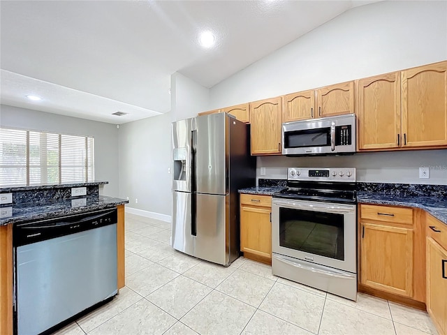 kitchen featuring light tile patterned floors, visible vents, vaulted ceiling, appliances with stainless steel finishes, and dark stone countertops