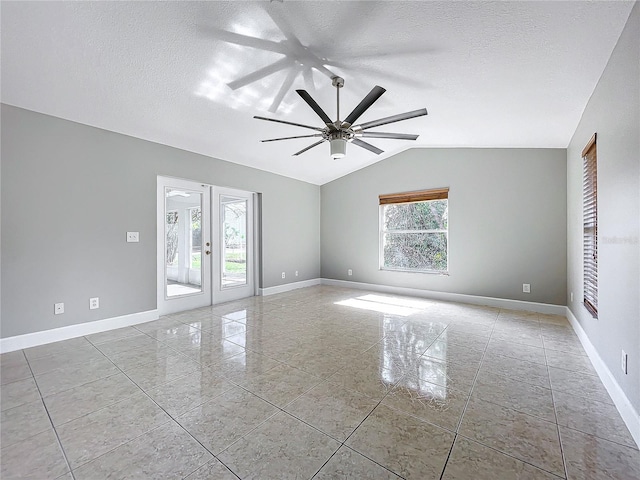 spare room with a textured ceiling, french doors, lofted ceiling, and baseboards