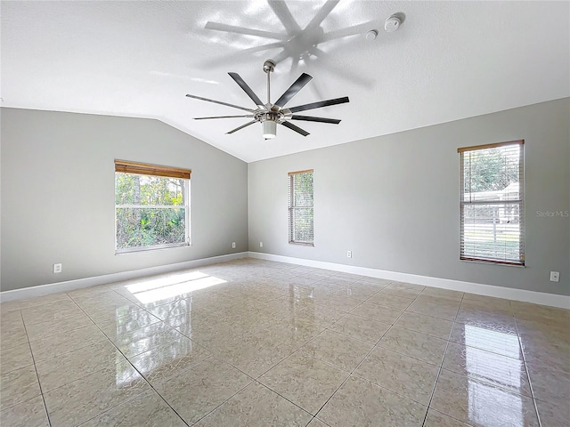 unfurnished room featuring vaulted ceiling, a textured ceiling, and baseboards