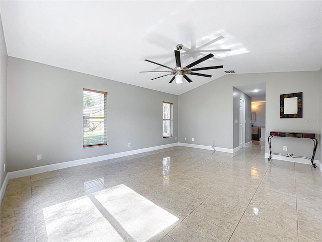 empty room featuring lofted ceiling, ceiling fan, visible vents, and baseboards