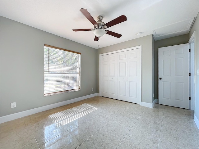 unfurnished bedroom with ceiling fan, a closet, and baseboards