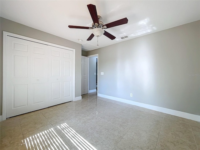 unfurnished bedroom featuring baseboards, visible vents, ceiling fan, and a closet