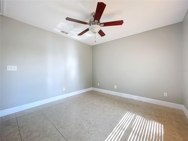 spare room featuring a ceiling fan, visible vents, and baseboards