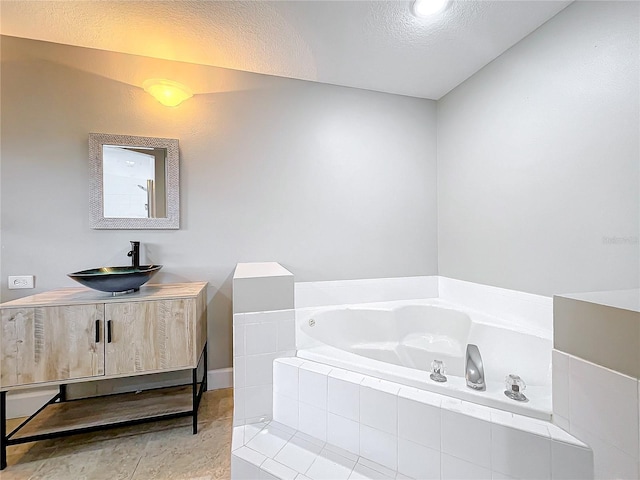 bathroom featuring a garden tub, vanity, and tile patterned floors