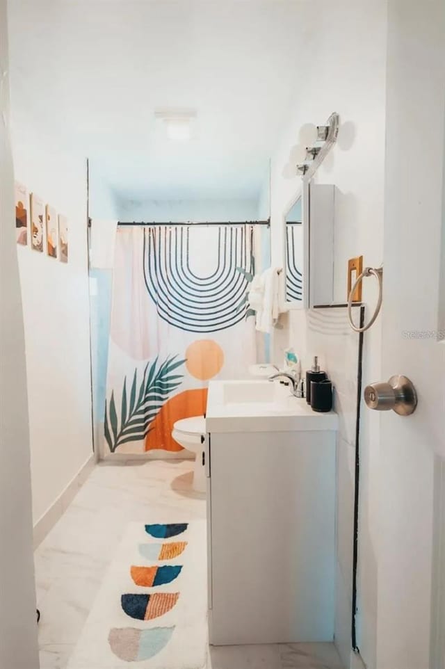 bathroom with vanity, a shower with shower curtain, and toilet