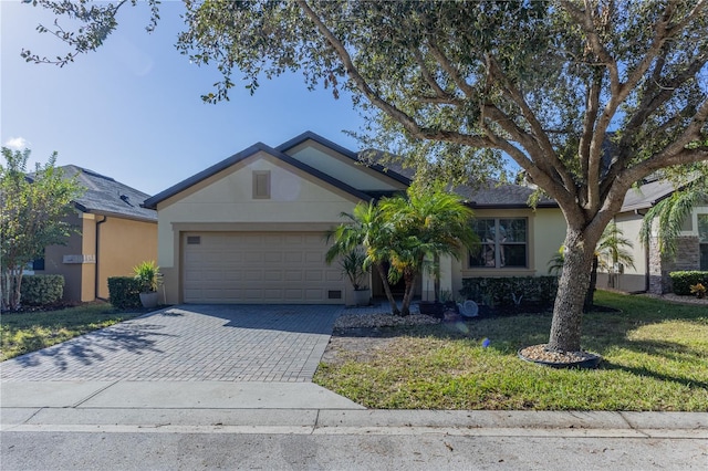 single story home featuring a garage and a front lawn