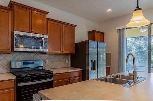 kitchen featuring appliances with stainless steel finishes, backsplash, hanging light fixtures, and sink