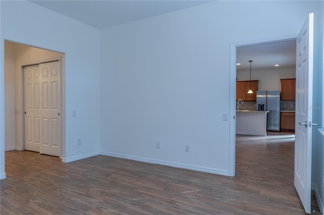 unfurnished room with dark wood-type flooring and sink