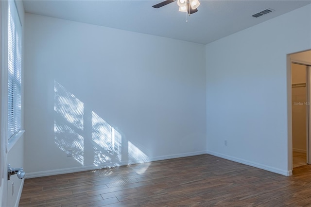 empty room with dark hardwood / wood-style floors, ceiling fan, and plenty of natural light