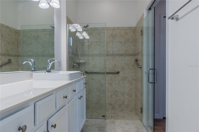 bathroom with tile patterned floors, vanity, and a shower with door