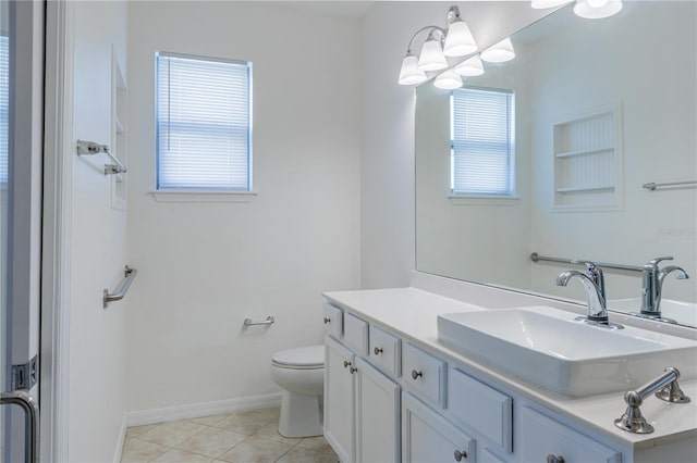 bathroom with tile patterned floors, vanity, toilet, and a chandelier