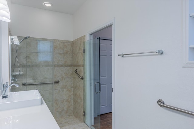 bathroom featuring wood-type flooring, vanity, and a shower with shower door