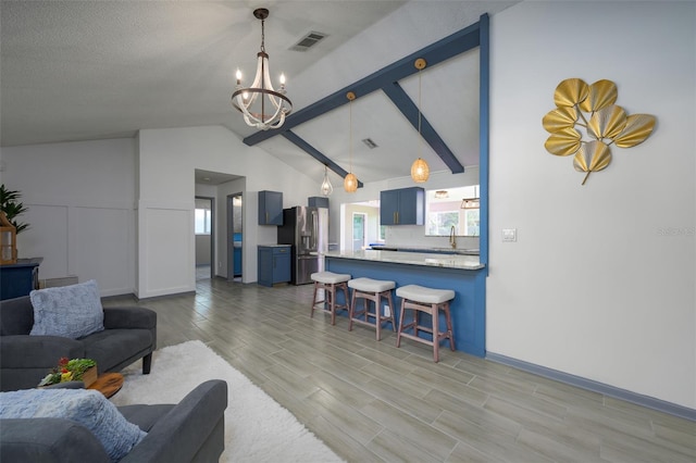 living room featuring an inviting chandelier, lofted ceiling, and sink